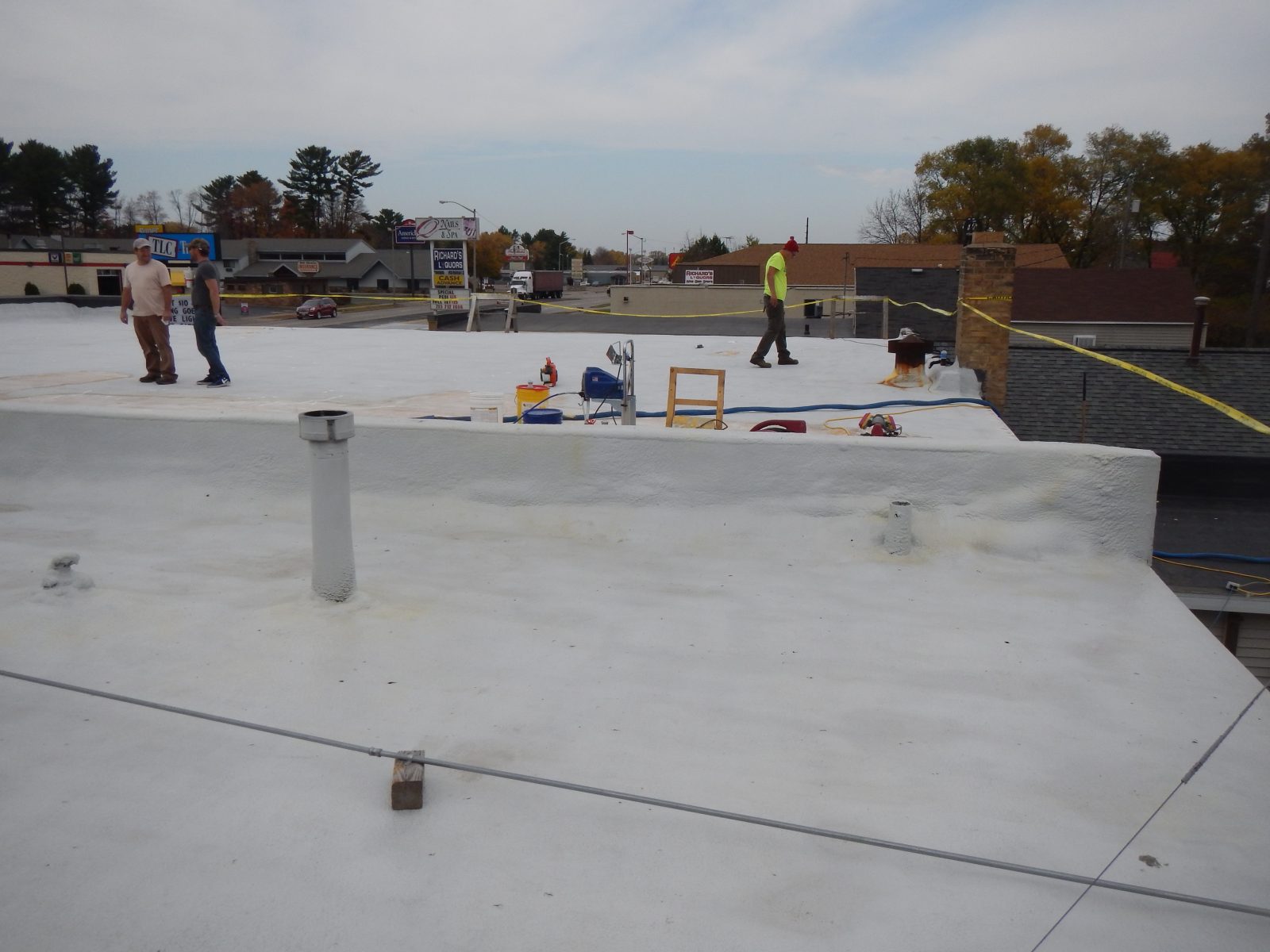 Metal roof panel seams sealed with sprayed polyurea membrane